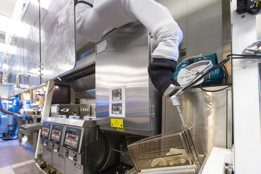 Miso Robotics' Flippy ROAR grabs a basket of cheese sticks for the fryer at a White Castle in Merrillville, Ind., on July 6, 2021. This location is testing "Flippy ROAR," a robotic fryer by Miso Robotics and an automated voice that takes orders at the drive-thru.