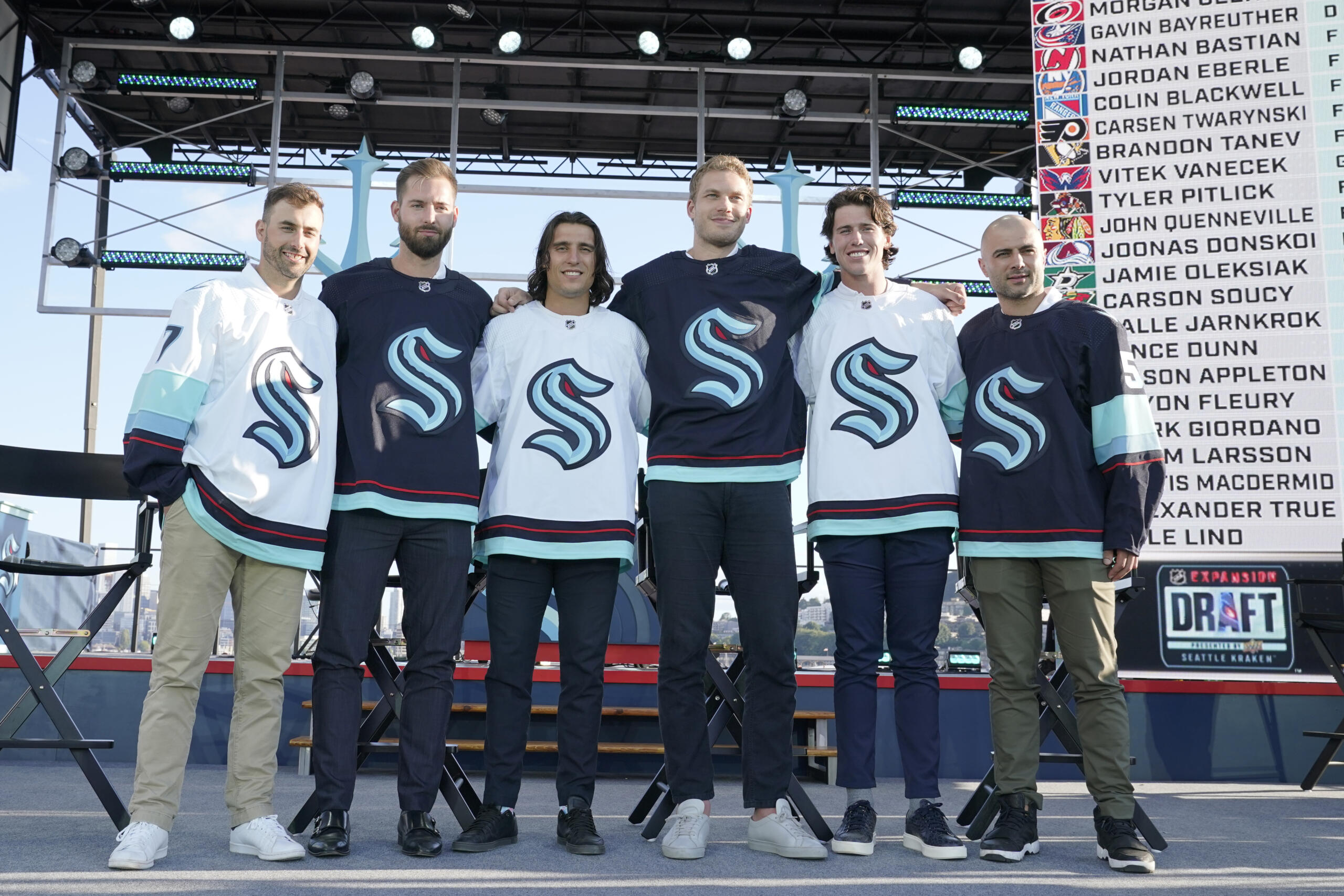 Seattle Kraken NHL hockey players Jordan Eberle, Chris Dreidger, Brandon Tanev, Jamie Oleksiak, Hadyn Fluery and Mark Giordano, from left, pose for a photo Wednesday, July 21, 2021, after being introduced during the Kraken's expansion draft event in Seattle. (AP Photo/Ted S.