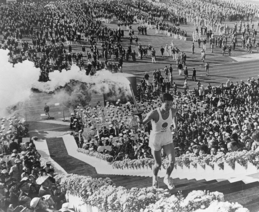 Yoshinori Sakai, born in Hiroshima on the day the first atomic bomb devastated the city, carries the torch up the stairs to light the cauldron during the opening ceremony for the 1964 Tokyo Summer Olympic Games.