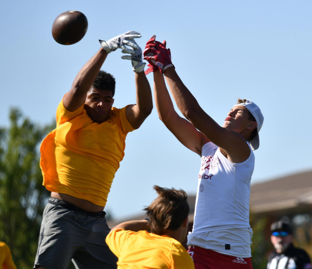 Players from Kelso and Sandy (Ore.) high school leap for a ball Saturday during the Rumble at the River 7-on-7 football tournament at Union High School.