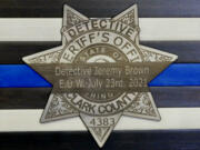 A memorial for Clark County sheriff's Detective Jeremy Brown depicts a mourning band over a badge with his end of watch date.
