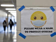 A sign encourages students and staff to wear their masks in a hall at Heritage High School in March.