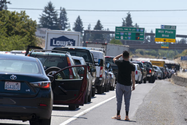 A motorist stuck in the southbound lanes of Interstate 205 near the Mill Plain Boulevard exit checks out the accident scene on Friday afternoon, July 9, 2021.