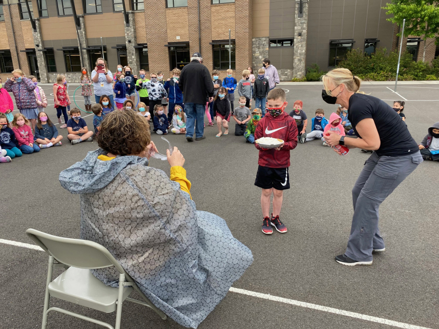 WASHOUGAL:  Columbia River Gorge Elementary School first-grader Jase Kenyon gets ready to smash Principal Tracey MacLachlan as teacher Jessica Warta observed.