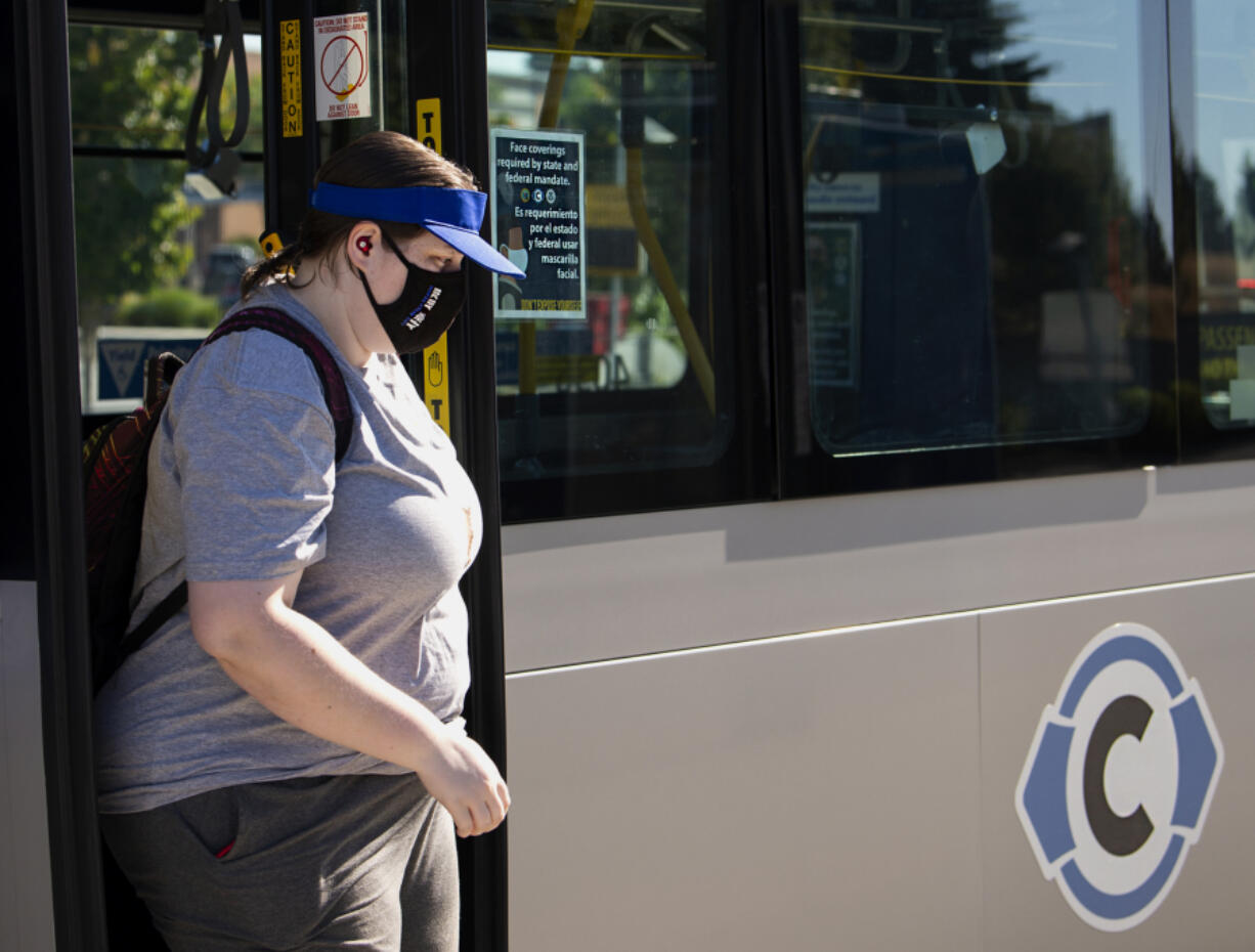 Vancouver resident Rachael Okerlund steps off a C-Tran bus wearing a face covering on Friday at the Vancouver Mall Transit Center. Face coverings remain a requirement on Vancouver public transit in accordance with CDC rules.