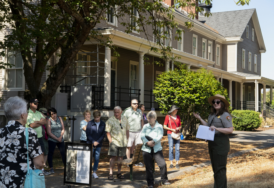 Guests listen to National Park Service curator Meagan Huff talk about the work immigrants performed at Vancouver Barracks in the 1880s. The former Infantry Barracks in the background now serves as headquarters of the Gifford Pinchot National Forest.