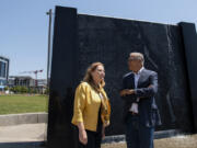 Vancouver Mayor Anne McEnerny-Ogle and Gov. Jay Inslee survey The Waterfront Vancouver while standing in front of an interactive sculpture that depicts the topography of the Columbia River on Tuesday. Inslee toured the waterfront with the mayor before meeting with local small-business owners.