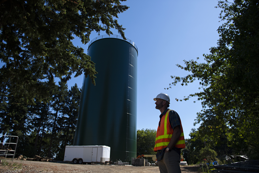 Tyler Clary, manager for water systems/water engineering for the city of Vancouver's water utility, pauses for a portrait with a 1 million gallon stand pipe at Water Station 1 in July 2021.
