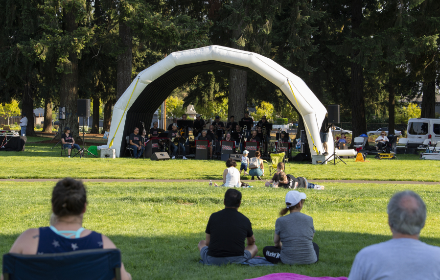 Visitors lounge in the grass to watch the Minidoka Swing Band on Thursday at a new park at Northeast 52nd Street and 137th Avenue in Vancouver's North Image neighborhood. Residents will be able to vote on the new park's name.