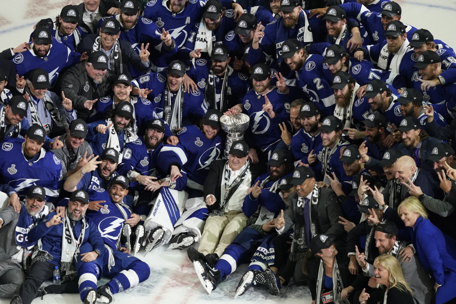 The Tampa Bay Lightning team poses with the Stanley Cup after Game 5 of the NHL hockey Stanley Cup finals against the Montreal Canadiens, Wednesday, July 7, 2021, in Tampa, Fla.