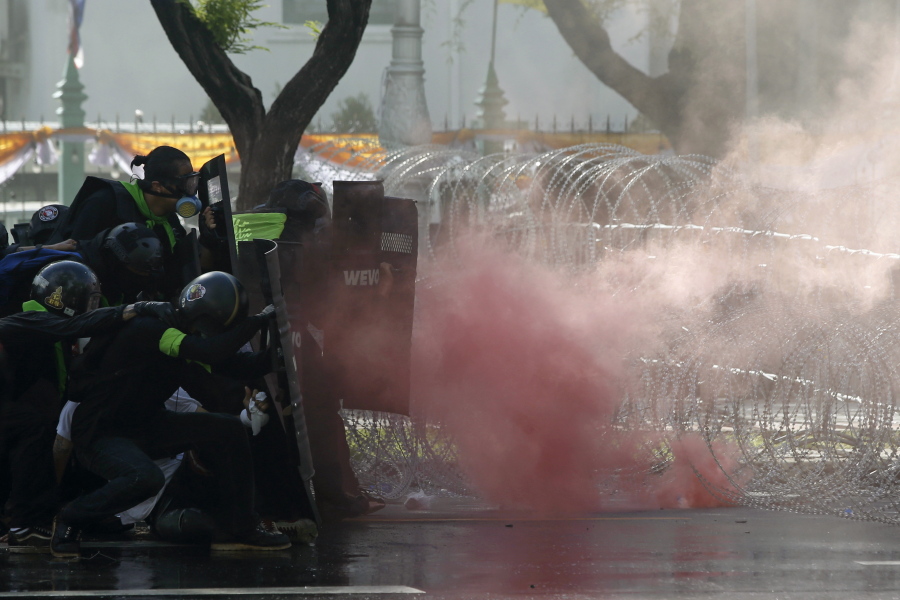 Riot police launch tear gas to protesters marching to Government House in Bangkok, Thailand Sunday, July 18, 2021. Hundreds of anti-government protesters rallied on Sunday despite the government's recent measures to prohibit the gathering of more than 5 people in the capital to curb the COVID-19 pandemic.