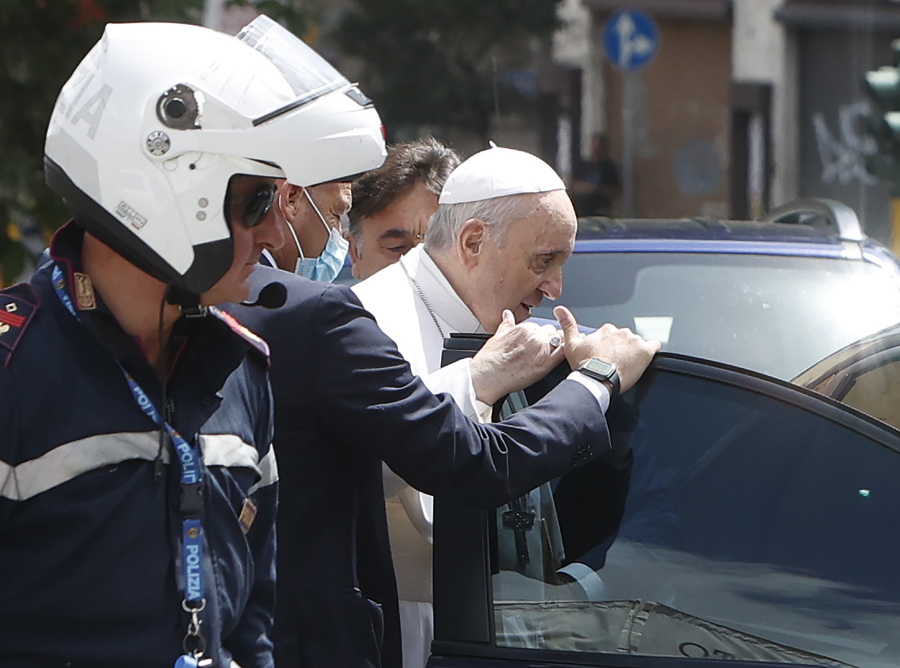 Pope Francis stops to greet police that escorted him as he arrives at the Vatican after leaving the hospital on his Ford, 10 days after undergoing planned surgery to remove half his colon Wednesday, July 14, 2021. Francis had half of his colon removed for a severe narrowing of his large intestine on July 4, his first major surgery since he became pope in 2013.