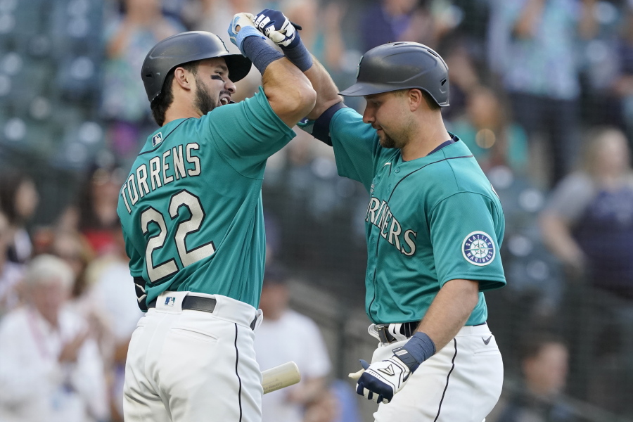 Seattle Mariners' Cal Raleigh, right, is greed by Luis Torrens (22) after Raleigh hit a two-run home run against the Oakland Athletics during the second inning of a baseball game, Friday, July 23, 2021, in Seattle. Torrens hit a solo home run in his ensuing at-bat. (AP Photo/Ted S.