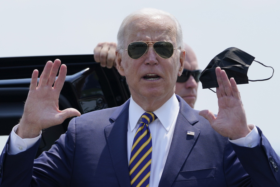 President Joe Biden holds a mask as he responds to a question as he arrives at Lehigh Valley International Airport in Allentown, Pa., Wednesday, July 28, 2021. Biden is in the area to visit the Lehigh Valley operations facility for Mack Trucks and advocate for government investments and clean energy as ways to strengthen U.S. manufacturing.