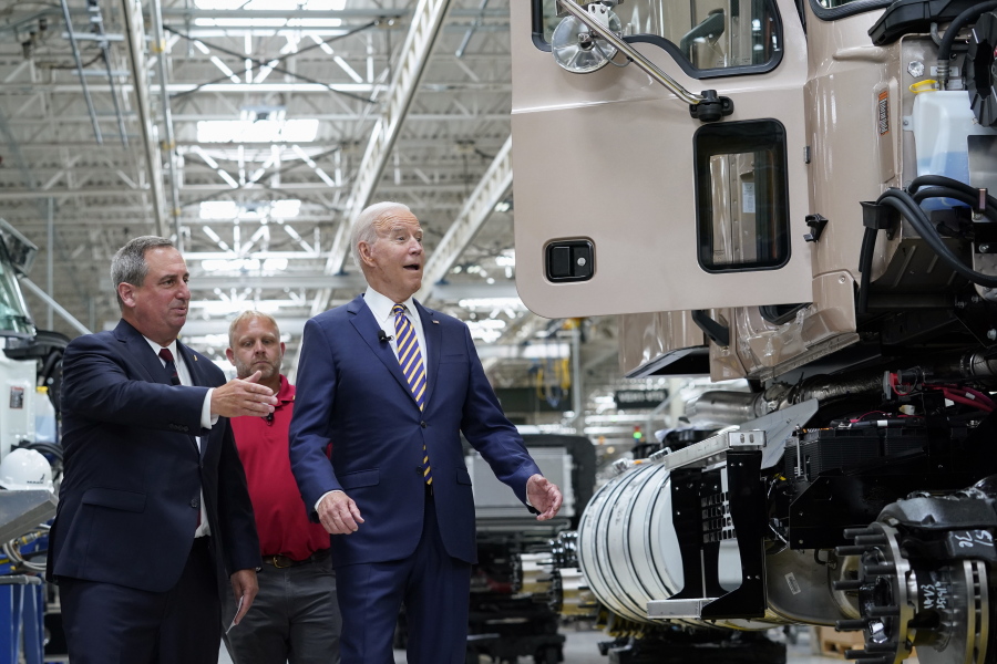 President Joe Biden reacts as Mack Trucks President Martin Weissburg, left, speaks during a tour of the Lehigh Valley operations facility for Mack Trucks in Macungie, Pa., Wednesday, July 28, 2021. UAW Local 677 Shop Chairman Kevin Fronheiser is at center.