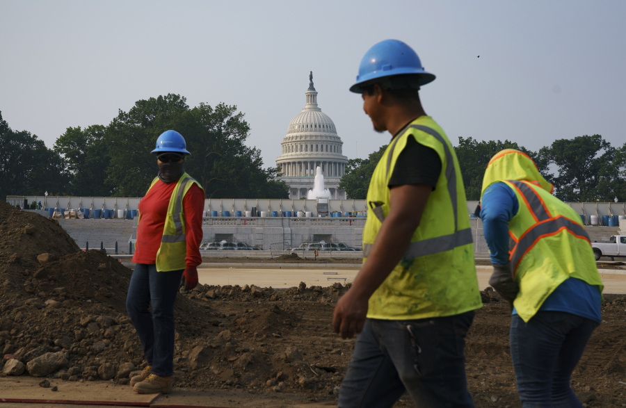 Workers repair a park near the Capitol in Washington, Wednesday, July 21, 2021, as senators struggle to reach a compromise over how to pay for nearly $1 trillion in public works spending, a key part of President Joe Biden's agenda. (AP Photo/J.