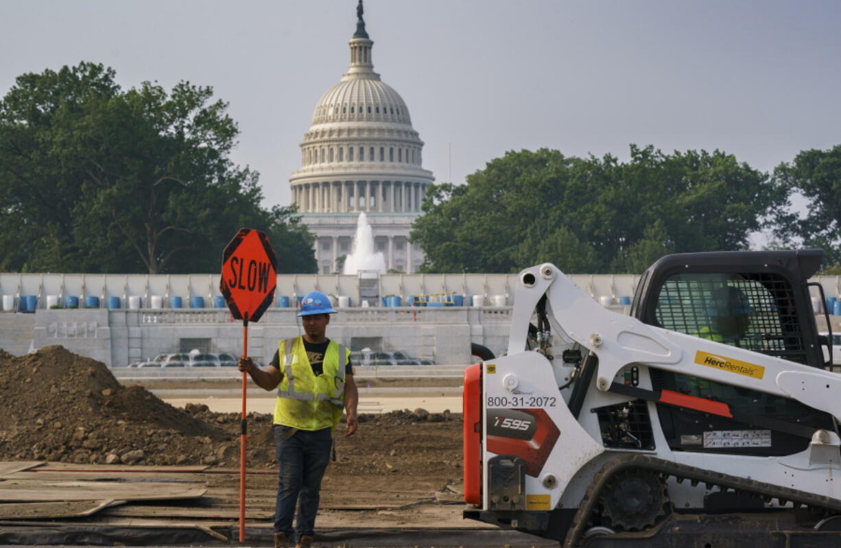 Workers repair a park near the Capitol in Washington, Wednesday, July 21, 2021, as senators struggle to reach a compromise over how to pay for nearly $1 trillion in public works spending, a key part of President Joe Biden's agenda. (AP Photo/J.