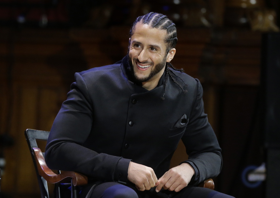 FILE - In this Oct. 11, 2018, file photo, former NFL football quarterback Colin Kaepernick smiles on stage during W.E.B. Du Bois Medal ceremonies at Harvard University, in Cambridge, Mass.