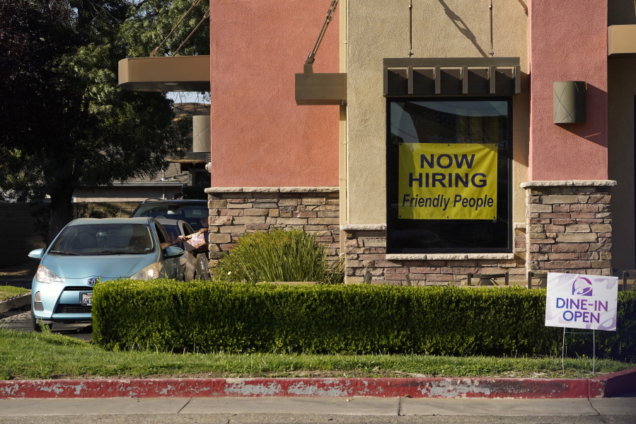 A hiring sign hangs in the window of a Taco Bell in Sacramento, Calif., Thursday, July 15, 2021. Hiring in California slowed down in June as the unemployment rate held steady at 7.7% according to new numbers released on Friday, July 16, 2021 by the Employment Development Department. California gained 73,000 jobs in June, ending the state's streak of four consecutive months of adding 100,000 jobs or more.