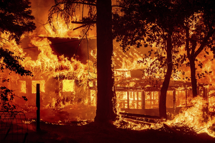 Flames from the Dixie Fire consume a home in the Indian Falls community of Plumas County, Calif., Saturday, July 24, 2021. The fire destroyed multiple residences as it tore through the area.