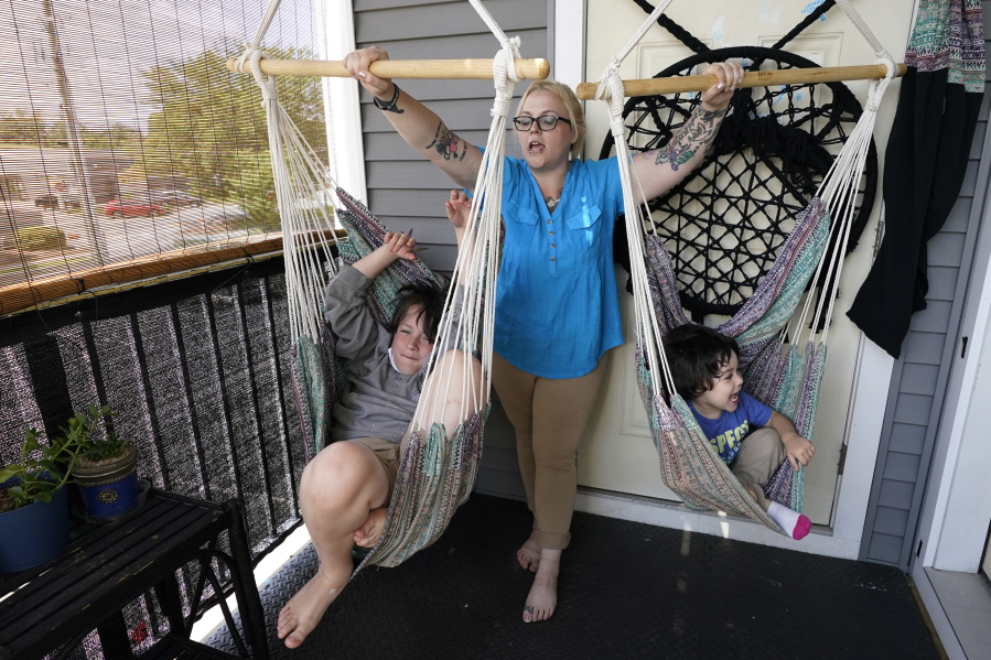In this July 28, 2021 photo, Christina Darling plays with her sons Kayden, 10, left, and Brennan, 4, at home in Nashua, N.H. Darling and her family have qualified for the expanded child tax credit, part of President Joe Biden's $1.9 trillion coronavirus relief package. "Every step closer we get to a livable wage is beneficial. That is money that gets turned around and spent on the betterment of my kids and myself," said Darling, a housing resource coordinator who had been supplementing her $35,000-a-year salary with monthly visits to the Nashua Soup Kitchen and Shelter's food pantry.