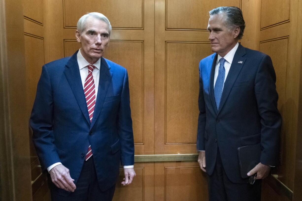 Sen. Rob Portman, R-Ohio, left, accompanied by Sen. Mitt Romney, R-Utah, leave in the elevator after a closed door talks about infrastructure on Capitol Hill in Washington Thursday, July 15, 2021.