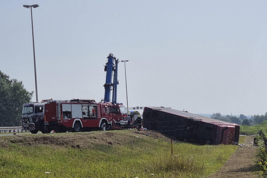 Emergency crews work at the site of a bus accident near Slavonski Brod, Croatia, Sunday, July 25, 2021. A bus swerved off a highway and crashed in Croatia early Sunday, killing 10 people and injuring at least 30 others, police said.