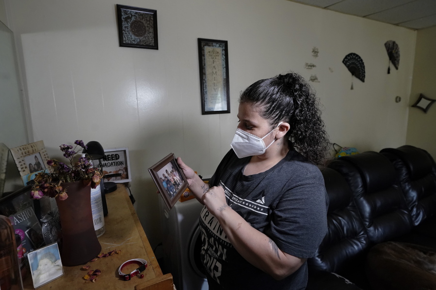 Roxanne Schaefer holds a photograph in the living room of her apartment, in West Warwick, R.I., Tuesday, July 27, 2021. Schaefer, who is months behind on rent, is bracing for the end to a CDC federal moratorium Saturday, July 31, 2021, a move that could result in millions of people being evicted just as the highly contagious delta variant of the coronavirus is rapidly spreading.
