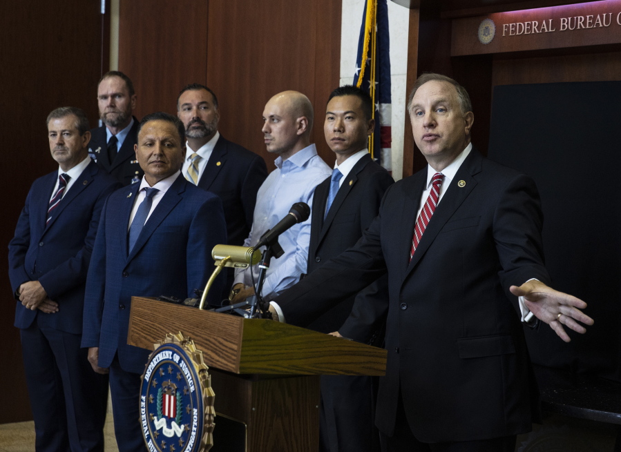 Special Agent in Charge Aaron Rouse of the FBI Las Vegas Field Office speaks as Acting U.S. Attorney Christopher Chiou, second right, looks on during a news conference at the FBI Las Vegas Field Office, Wednesday, July 14, 2021, in Las Vegas. U.S. officials declared they dismantled a key international cocaine and money-laundering hub in an ongoing investigation that began in Las Vegas and has involved at least 30 other countries. The top federal prosecutor and FBI chief in Las Vegas said the recent arrests of six people in Nevada, Arizona, California and Washington state came as part of the six-year probe.