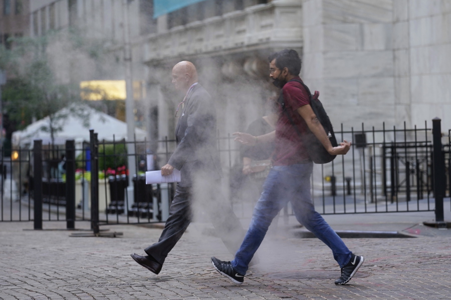 People walk through steam from a street grating outside the New York Stock Exchange, Wednesday, June 16, 2021. Stocks are off to a mixed start on Wall Street as traders wait for the latest U.S. monthly jobs report due out Friday, July 2. The S&P 500 was little changed in the early going Wednesday, June 30.