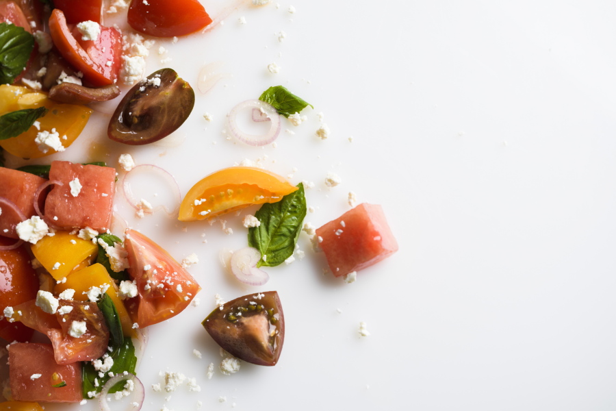 This image released by Milk Street shows a recipe for watermelon salad with tomato, basil and goat cheese.