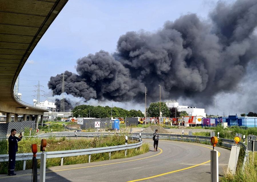 A dark cloud of smoke rises above the chemical park in Leverkusen, Germany, Tuesday, July 27, 2021. Firefighters from the site fire department are on duty.