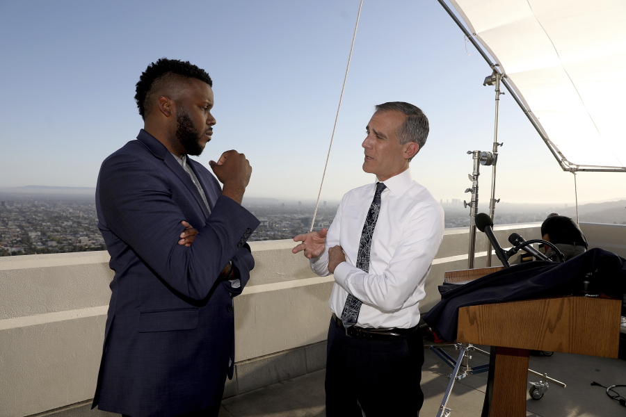 FILE - In this April 19, 2021 file photo, Los Angeles Mayor Eric Garcetti, right, talks with Michael Tubbs, founder of Mayors for a Guaranteed Income, after holding his annual State of the City address from the Griffith Observatory, in Los Angeles. In experiments across the country, dozens of cities and counties, some using money from the $1.9 trillion COVID relief package approved in March, and the state of California are giving some low-income residents a guaranteed income of $500 to $1,000 each month to do with as they please, and tracking what happens.