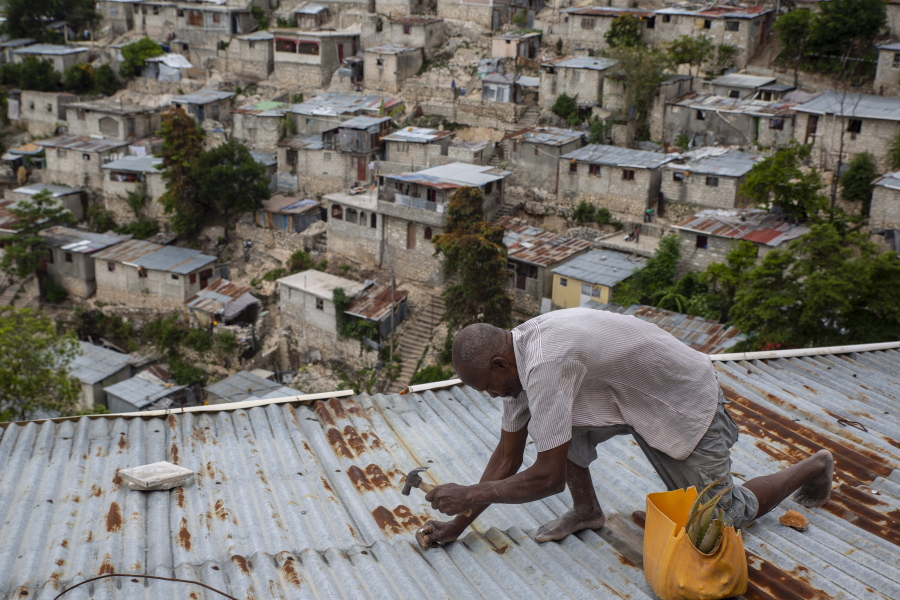 Antony Exilien secures the roof of his house in response to Tropical Storm Elsa, in Port-au-Prince, Haiti, Saturday, July 3, 2021. Elsa brushed past Haiti and the Dominican Republic on Saturday and threatened to unleash flooding and landslides before taking aim at Cuba and Florida.