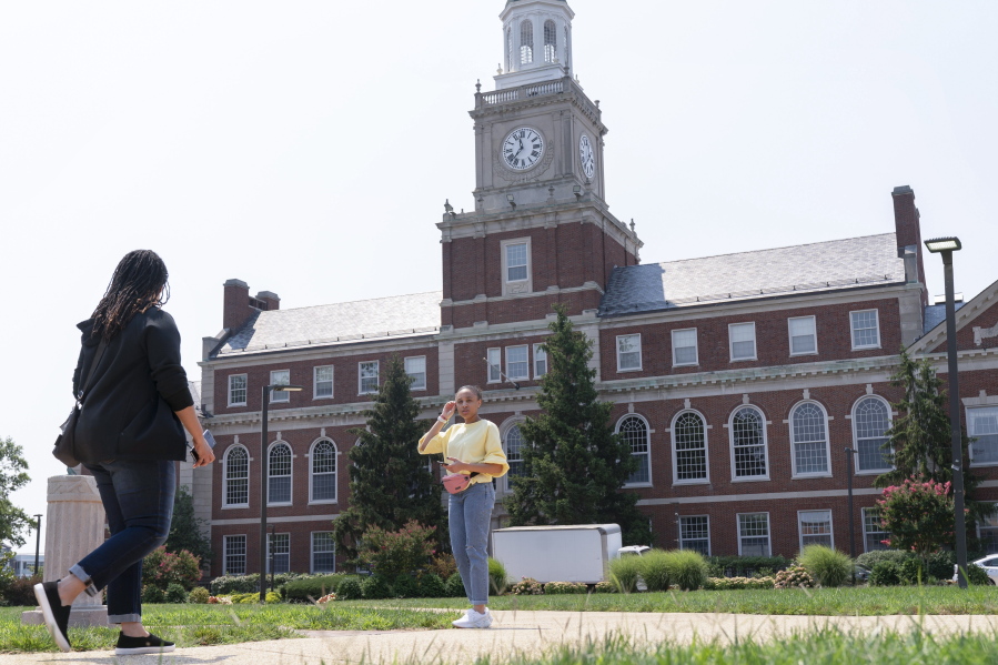 FILE - In this July 6, 2021, file photo with the Founders Library in the background, people walk along the Howard University campus in Washington. With the surprise twin hiring of two of the country's most prominent writers on race, Howard University is positioning itself as one of the primary centers of Black academic thought just as America struggles through a painful crossroads over historic racial injustice.