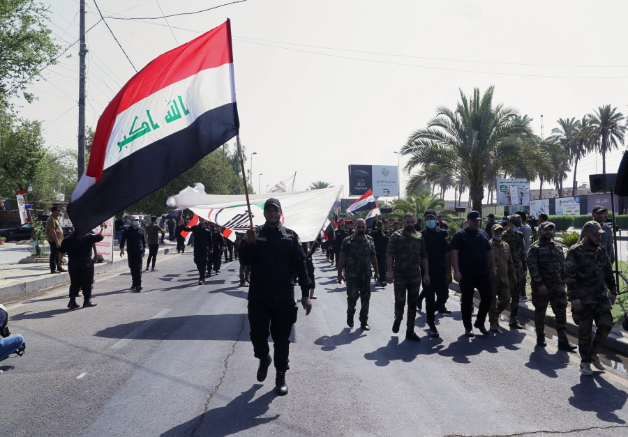 Iran-backed militia fighters march in central Baghdad, Iraq, Tuesday, June 29, 2021. Iraqi Shiite militias are showing a degree of defiance of their patron Iran by escalating rocket and drone attacks on the U.S. presence in the country, militia and Shiite political leaders say. Iran has been pushing the factions to keep calm in Iraq while it holds nuclear negotiations with the United States.