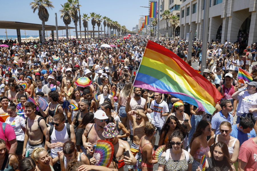 FILE - In this June 25, 2021 file photo, people participate in the annual Pride Parade, in Tel Aviv, Israel.  On Sunday, July 11, 2021, Israel's Supreme Court cleared the way for same-sex couples to have children through surrogate mothers, a move hailed by lawmakers and activists as a victory for LGBTQ rights.