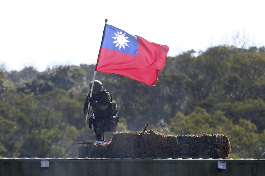 FILE - In this  Jan. 19, 2021, file photo, a soldier holds a Taiwanese flag during a military exercise aimed at repelling an attack from China in Hsinchu County, northern Taiwan. Japan believes rising tension surrounding Taiwan requires its attention "with a sense of crisis" as China intensifies military activities in the area and the United States steps up support for the self-governing island.