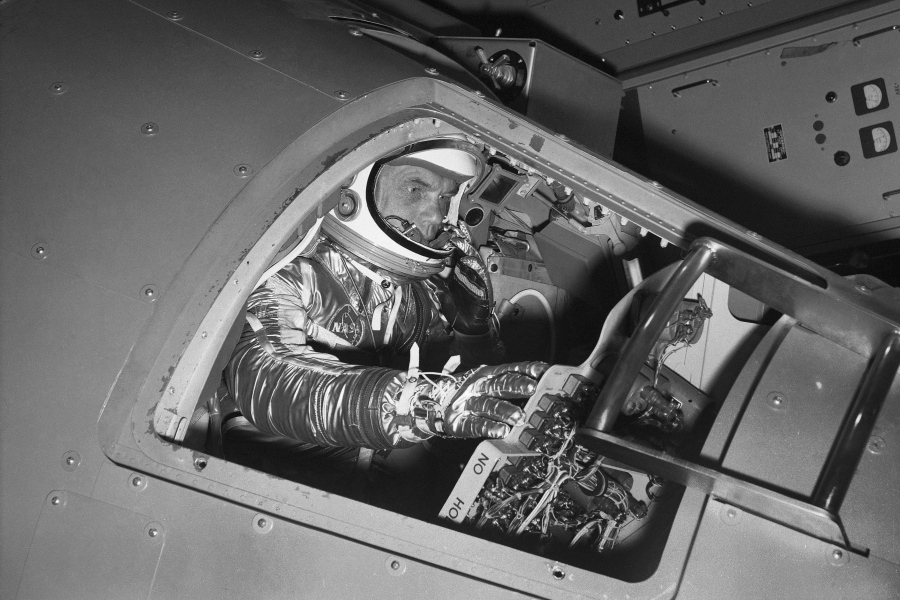 FILE - In this Jan. 11, 1961 file photo, then Marine Lt. Col. John Glenn reaches for controls inside a Mercury capsule procedures trainer as he shows how the first U.S. astronaut will ride through space during a demonstration at the National Aeronautics and Space Administration Research Center in Langley Field, Va. Glenn's birthplace and childhood hometown in Ohio are celebrating what would have been the history-making astronaut and U.S. senator's 100th birthday with a three-day festival from July 16 through July 18, 2021.