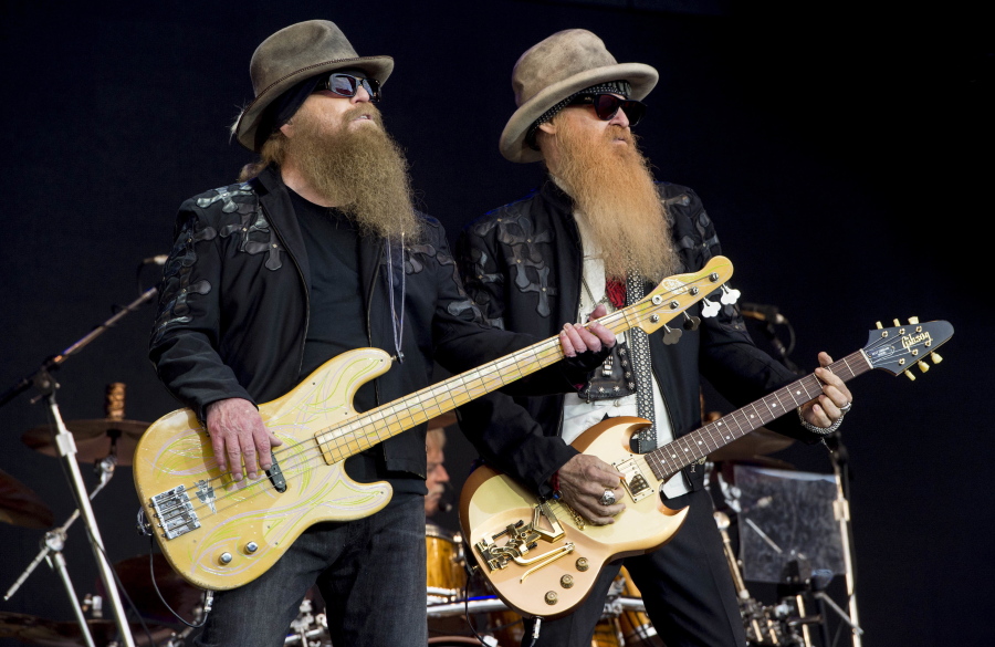 FILE - Dusty Hill, left, and Billy Gibbons from U.S rock band ZZ Top perform at the Glastonbury music festival in Somerset, England, June 24, 2016. ZZ Top has announced that Hill, one of the Texas blues trio's bearded figures and bassist, has died at his Houston home. He was 72. In a Facebook post, bandmates Billy Gibbons and Frank Beard revealed Wednesday, July 29, 2021, that Hill had died in his sleep.