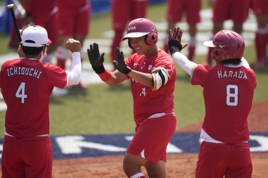 Japan's Minori Naito, center, celebrates with her teammates after hitting a two run home run during the softball game between Japan and Australia at the 2020 Summer Olympics, Wednesday, July 21, 2021, in Fukushima, Japan. (AP Photo/Jae C.
