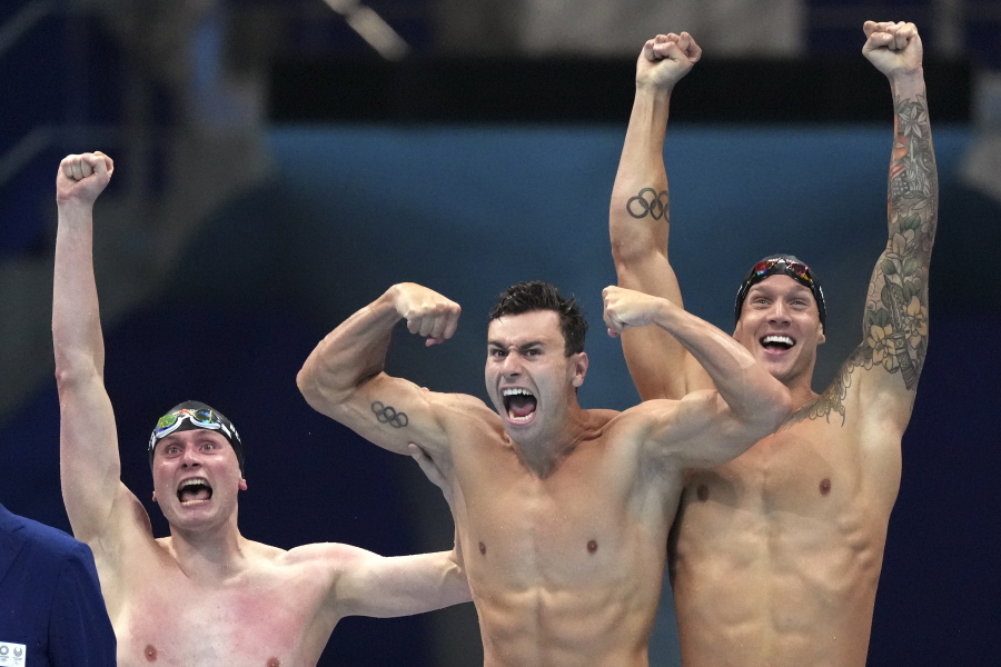 United States men's 4x100m freestyle relay team Bowen Beck, Blake Pieroni, and Caeleb Dressel celebrate after winning the gold medal at the 2020 Summer Olympics, Monday, July 26, 2021, in Tokyo, Japan.