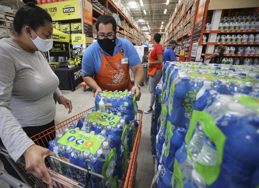 Home Depot department supervisor, Arnaldo Gonzalez, loads water bottles into Elena Arvalo's shopping cart as shoppers prepare for possible effects of tropical storm Elsa in Miami on Saturday, July 3, 2021. Elsa fell back to tropical storm force as it brushed past Haiti and the Dominican Republic on Saturday and threatened to unleash flooding and landslides before taking aim at Cuba and Florida.