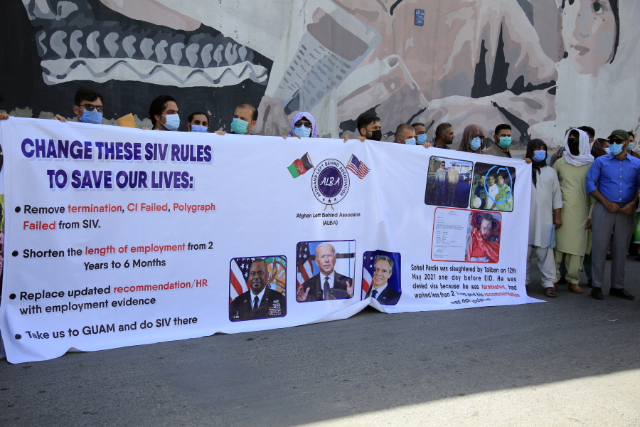 In this June 25, 2021 photo, former Afghan interpreters hold placards during a demonstrations against the US government, in front of the US Embassy in Kabul, Afghanistan.  The Biden administration says it will evacuate about 2,500 Afghans who worked for the U.S. government and their families to a military base in Virginia pending approval of their visas. The administration notified Congress on Monday that the Afghans will be housed at the Fort Lee Army base south of Richmond starting next week.