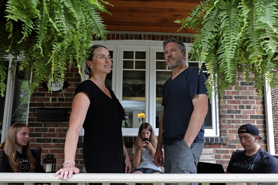 Amanda and David Wood stand as their children, twins Ruby and Lola, and Ethan sit on the porch of their family home in Toronto, Canada, on Monday, July 12, 2021. When Amanda heard that hundreds of coronavirus shots were available for teens, only one thing prevented her from racing to the vaccination site at a Toronto high school - her 13-year-old daughter's fear of needles.