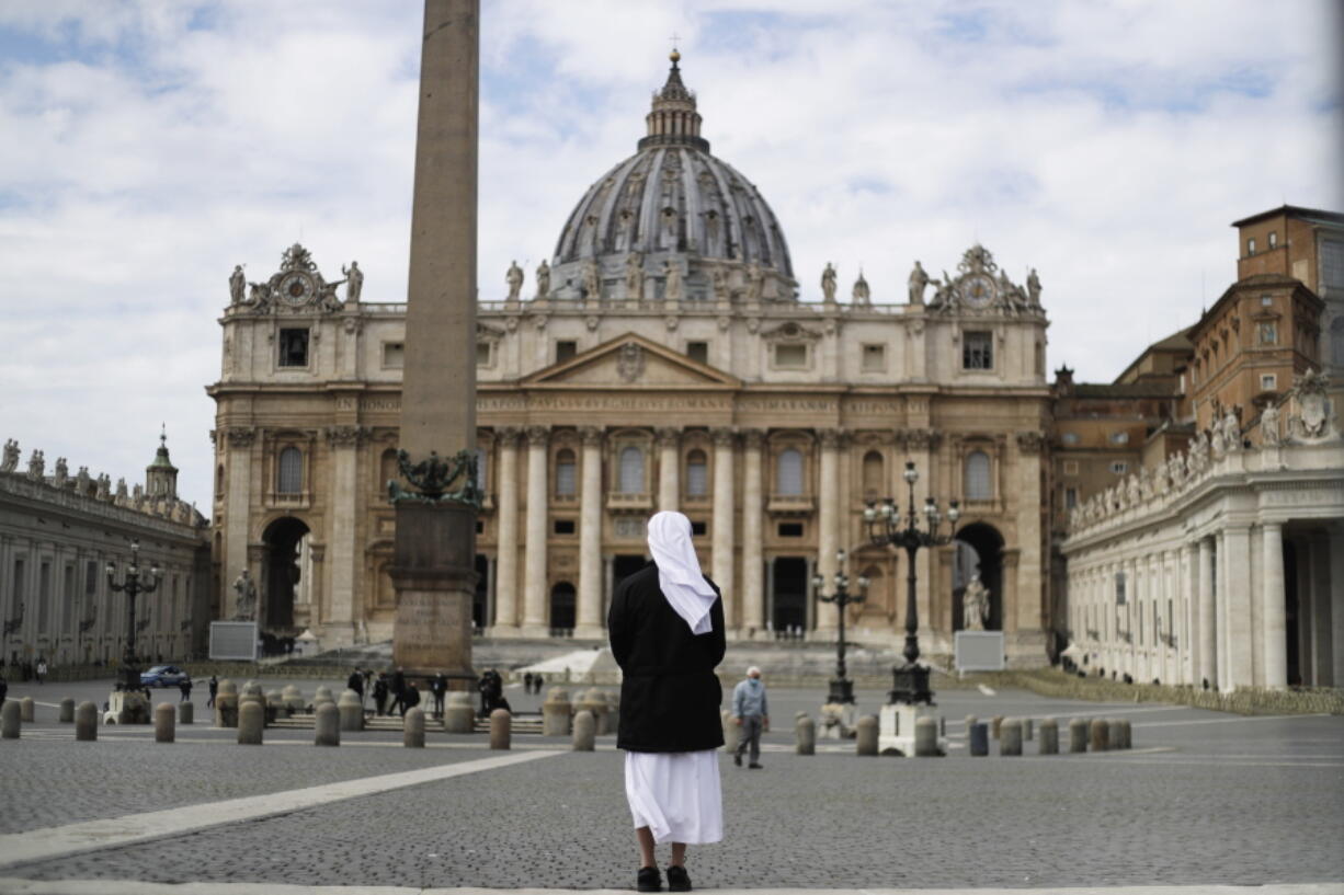 FILE - In this Sunday, March 21, 2021 filer, a nun stands in St. Peter's Square at the Vatican. Vatican prosecutors have alleged a jaw-dropping series of scandals in launching the biggest criminal trial in the Vatican's modern history, which opens Tuesday in a modified courtroom in the Vatican Museums. The once-powerful cardinal and nine other people are accused of bleeding the Holy See of tens of millions of dollars in donations through bad investments, deals with shady money managers and apparent favors to friends and family.