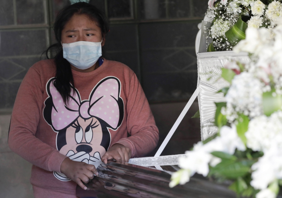 Luciana Vilca, 12, stands next the coffin of her father, Javier Vilca, in Arequipa, Peru, Friday, June 25, 2021. Javier Vilca jumped to his death from a hospital while being treated for the coronavirus. The hospital was overcrowded and overwhelmed by the crisis.