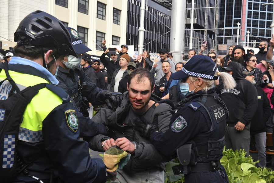 A protester, center, is arrested by police at a demonstration at Sydney Town Hall during a 'World Wide Rally For Freedom' anti-lockdown rally in Sydney, Saturday, July 24, 2021.