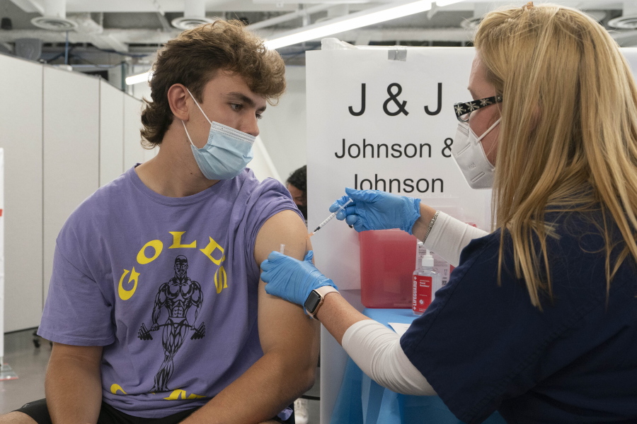 Bradley Sharp, of Saratoga, N.Y., gets a shot from registered nurse Stephanie Wagner on Friday in New York. New York City announced Wednesday that anyone can receive $100 if they get the first dose of the COVID-19 vaccine at any city-run vaccination clinic.