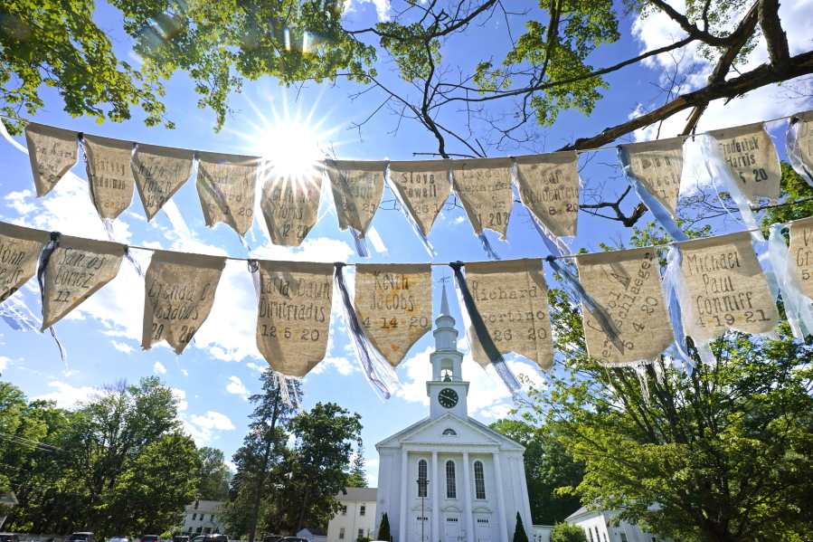 Flags with names of people who died from COVID-19 are displayed outside the First Congressional Church last month in Holliston, Mass. The flags are part of the COVID Art and Remembrance project spearheaded by Jaclyn Winer, whose father, Keith Jacobs, died in April 2020 from the coronavirus.